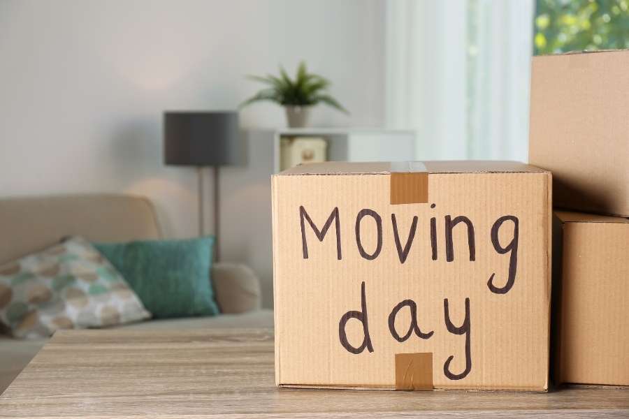 Un carton marqué Moving day posé sur une table en bois lors d'un déménagement à Neuilly-sur-Seine.
